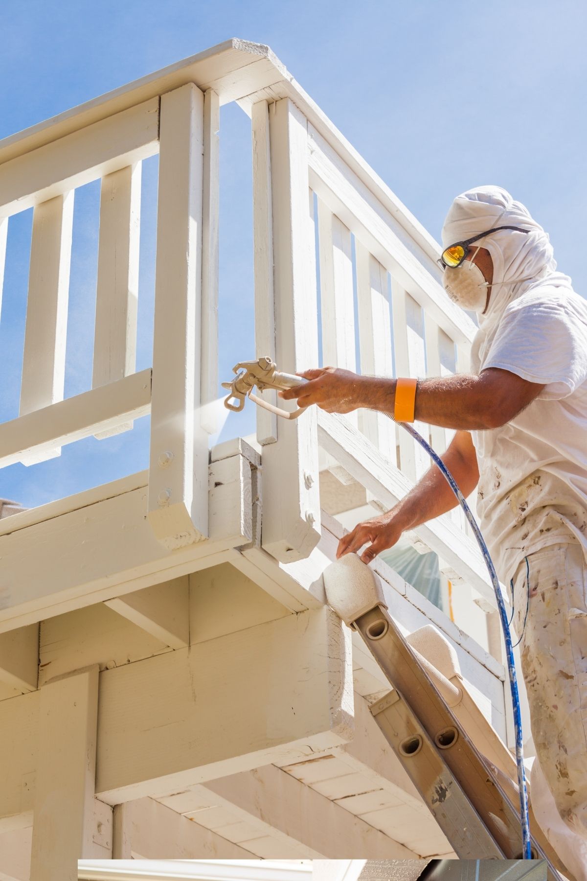Peintre en bâtiment à Boucherville appliquant une couche de peinture blanche